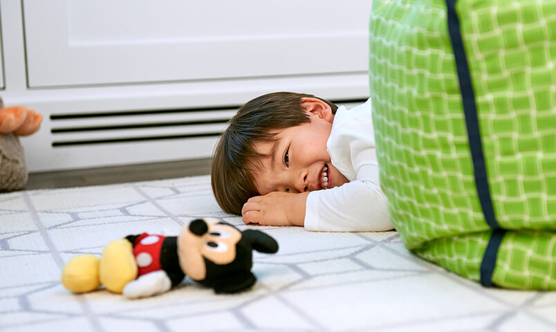 Niño juega en el piso con Mickey Mouse de Disney