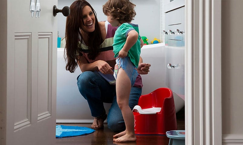 Mother helping little boy with potty training