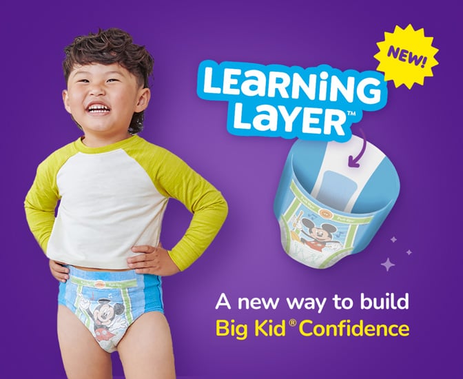 A young child standing confidently while wearing Pull‑Ups training pants
